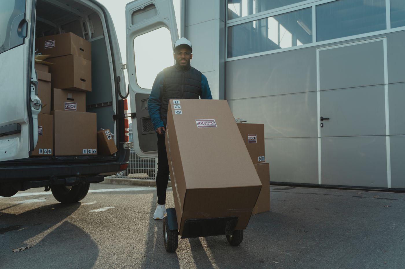 Receiver moving fragile boxes on a hand truck at the warehouse