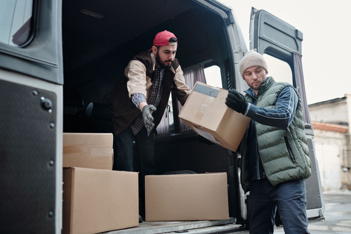 Receiving team unloading designer freight boxes from delivery van